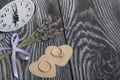 Wedding rings lie on hearts cut out of paper. Near a bunch of lavender and a clock. On brushed pine boards painted in black and Royalty Free Stock Photo