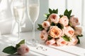 Wedding rings lie next to two glasses of champagne and a bouquet of roses Royalty Free Stock Photo