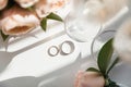 Wedding rings lie next to two glasses of champagne and a bouquet of roses Royalty Free Stock Photo