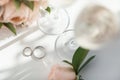 Wedding rings lie next to two glasses of champagne and a bouquet of roses Royalty Free Stock Photo