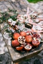 Wedding rings lie on a pomegranate on a plate on the table next to the bridal bouquet