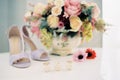 Wedding rings lie on sweets on the table near the bouquet of flowers and the bride shoes Royalty Free Stock Photo