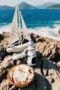 Wedding rings lie in a wicker plate near the model of a sailboat on the rocks Royalty Free Stock Photo