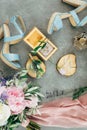 Wedding rings lie in a wooden box surrounded by sandals with heels, flowers and twigs, a bouquet and a scarf on the Royalty Free Stock Photo