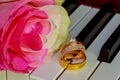 Wedding Rings on a piano keyboard and Flowers Royalty Free Stock Photo