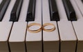 Wedding rings on the piano keys golden wedding rings lie on the piano free space for text Royalty Free Stock Photo