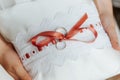 Wedding rings on a pillow with a red ribbon Royalty Free Stock Photo