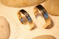 Wedding rings in the sand with stones