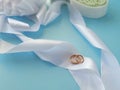 Wedding rings on silk ribbons on blue background.