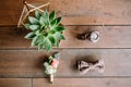 Wedding rings with succulent in glassed box, watch and boutonniere on wooden background. Flat lay. Top view Royalty Free Stock Photo