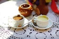 Wedding rings and two cups of hot white and milk chocolate on a white lace tablecloth, dessert, sweet, dcor, cafe, spoon