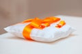 Wedding rings on a white pillow with orange ribbon Royalty Free Stock Photo