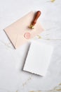 Wedding RSVP mockup and pink envelope with wax seal stamp on marble table. Flat lay, top view Royalty Free Stock Photo