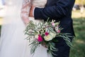 Wedding rustic bouquet with roses. Bride in a white dress and a groom in a suit are holding a beautiful bouquet of white, pink flo Royalty Free Stock Photo