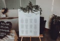 Wedding seating chart on the easel at light restaurant. Royalty Free Stock Photo