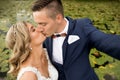 Wedding selfie. Bride and groom kissing passionately outdooors in park. Royalty Free Stock Photo