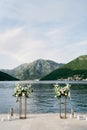 Wedding semi-arch stands on a pier by the sea