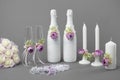 Bottles of champagne with blank labels, wine glasses, candles, brides garter and flower bouquet