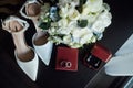 Wedding set of the bride. Shoes and rings lie next to the wedding bouquet Royalty Free Stock Photo