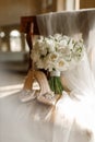 wedding shoes and bride\'s bouquet on a vintage chair Royalty Free Stock Photo