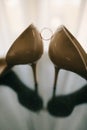 Wedding shoes and rings on glass table Royalty Free Stock Photo