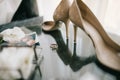 Wedding shoes and rings on glass table Royalty Free Stock Photo