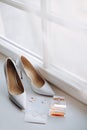 Wedding shoes, rings, invitation and perfume on the windowsill. Wedding details