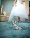 Wedding silver shoe closeup with a bride in background. High heels bridal shoe on carpet. Bride getting ready for special day Royalty Free Stock Photo