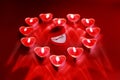 Wedding solitaire ring in heart shaped red box with heart shaped candle on red background. Valentine`s day concept.