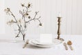 Wedding stationery mock-up. Blank business, RSVP paper card on plate. Festive table setting with brass candleholder