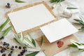 Wedding cards laying on marble table with olive tree branches Royalty Free Stock Photo