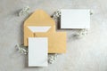 Wedding stationery set top view. Kraft paper envelopes and blank paper card decorated flowers on stone table. Vintage style. Flat