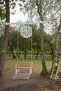 Wedding swing overgrown decorated with flowers hanging on the branches in the park Royalty Free Stock Photo