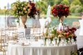 Wedding table arranged and decorated outdoors. Beautiful flowers on the table on the wedding day. Royalty Free Stock Photo