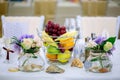 Wedding table arrangement with flower bouquets and fruit basket Royalty Free Stock Photo