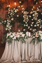 Wedding table banquet decorated with flowers and plants, retro lamps on a wooden background