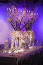 Wedding table with blue ambient lighting and white flower decor with floating candle containers Royalty Free Stock Photo