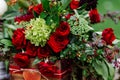 Wedding table decor: flowers composition with roses, berries, herbs and greenery standing in wooden box. Bridal details and decora