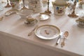 Wedding table decoration with expensive retro royal majesty porcelain service plates and cutlery in a palace