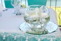 Wedding table decoration in a restaurant - glass sphere with white flowers, pearls and lace