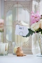 Wedding table decoration series - pink and white bouquet of flowers and a bird holding a table 1 sign Royalty Free Stock Photo