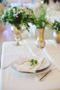 Wedding table place setting with flowers in golden vase. Selective focus. Grainy effect