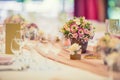 Wedding table setting. Beautiful table set with flowers and glass cups for some festive event, party or wedding reception Royalty Free Stock Photo