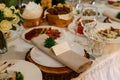 Wedding table setting with blank guest card, napkin, succulent on wooden plate. Rustic decor Royalty Free Stock Photo