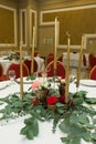 The wedding table setting is decorated with fresh flowers in a brass bowl and golden candles in brass candlesticks. Wedding Royalty Free Stock Photo