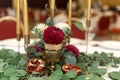 The wedding table setting is decorated with fresh flowers in a brass bowl and golden candles in brass candlesticks. Wedding Royalty Free Stock Photo