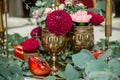 The wedding table setting is decorated with fresh flowers in a brass bowl and golden candles in brass candlesticks. Wedding Royalty Free Stock Photo