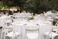 Wedding table setting decorated with fresh flowers in a brass vase. Wedding floristry. Banquet table for guests outdoors with a Royalty Free Stock Photo