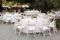 Wedding table setting decorated with fresh flowers in a brass vase. Wedding floristry. Banquet table for guests outdoors with a Royalty Free Stock Photo