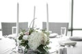 Wedding table setting is decorated with fresh flowers and white candles. Wedding floristry. Bouquet with roses, hydrangea and Royalty Free Stock Photo